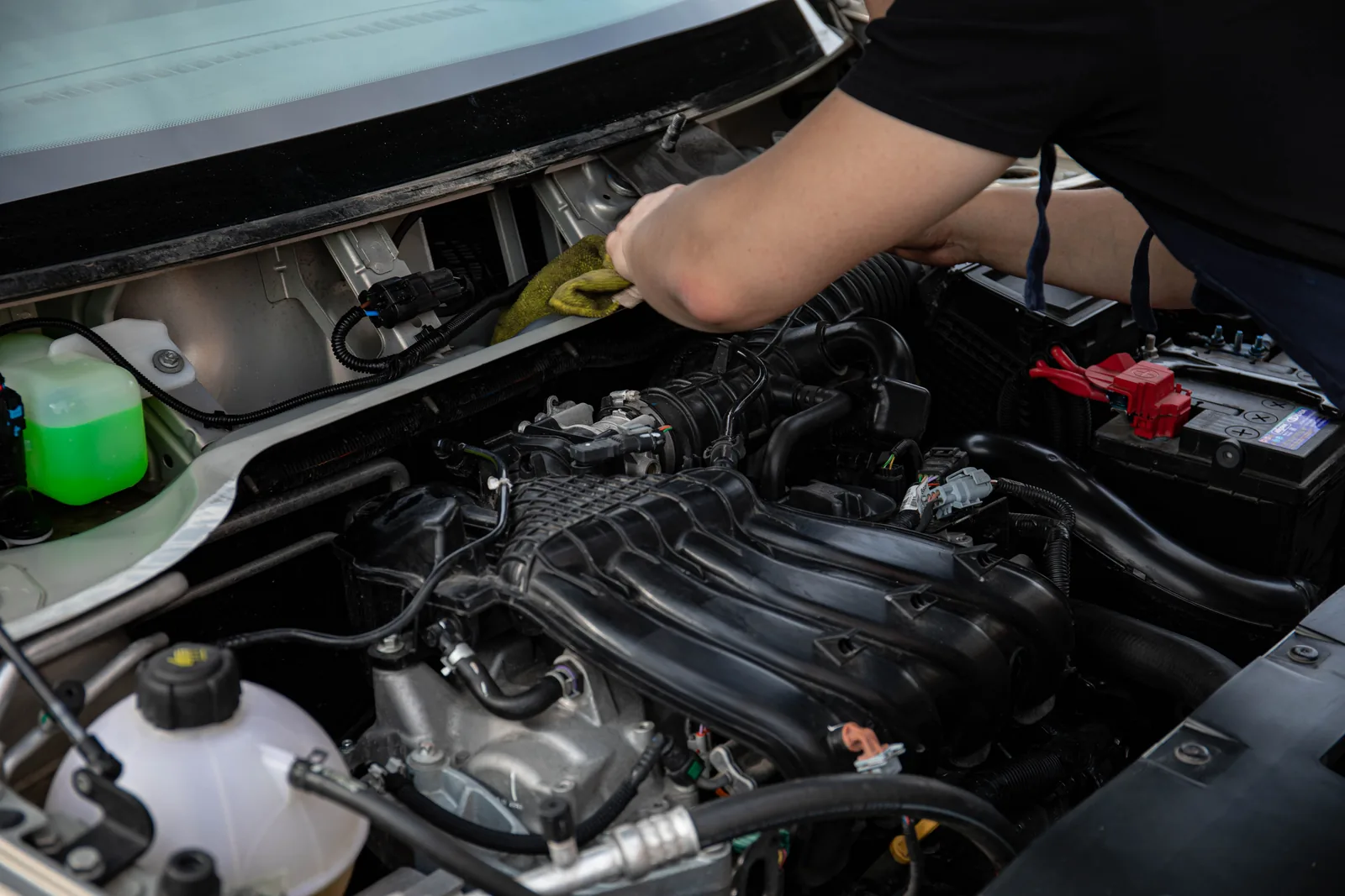Hand mit Werkzeug bei Motorarbeit; illustrative Stockfotografie